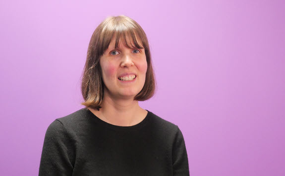Photograph of Sarah Cullen with a purple background.